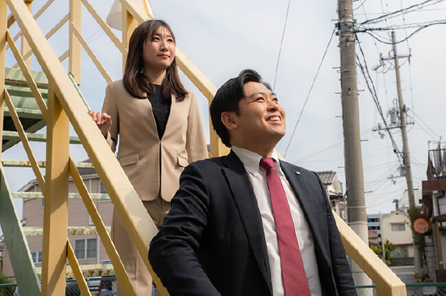 空を見上げる2人の社員